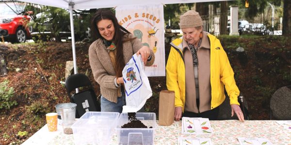 Young person with an old person pouring soil for a workshop