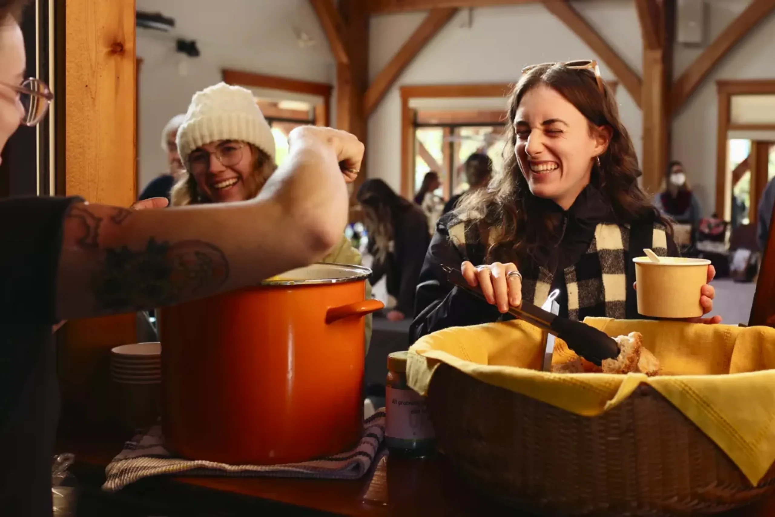 Person serving soup to other happy community members